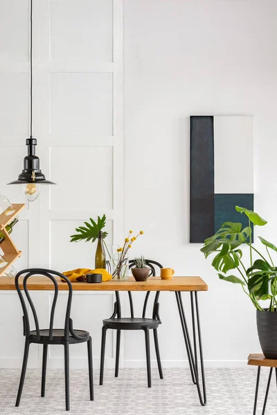 Elegant dining room interior with black wooden chairs and green plants — Stock Photo, Image