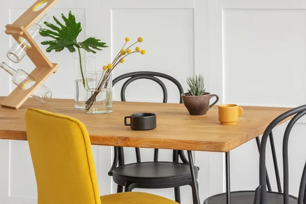 Stylish yellow chair at wooden dining table in trendy interior — 스톡 사진