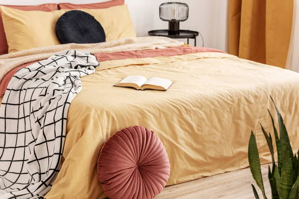 Svart rund sammetskudde på gul påslakan i trendigt sovrum interiör med king size-säng — Stockfoto