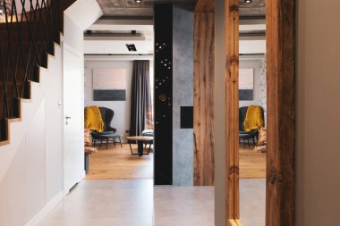 Koridorun duvarındaki aynada sarı battaniyeli arka koltuğu olan zarif odaya açık kapı var.