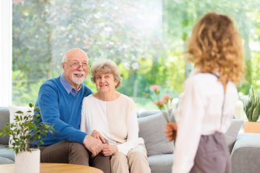 Büyükannelerin günü için elinde çiçeklerle bekleyen tatlı sarışın çocuk.