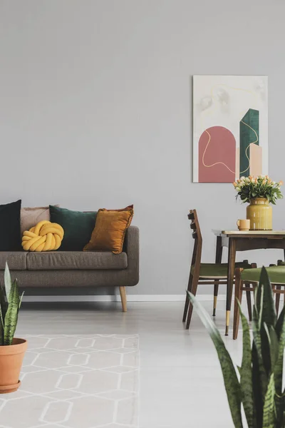 Interior ruang makan dan tinggal dengan sofa coklat dan meja kayu dengan kursi vintage — Stok Foto