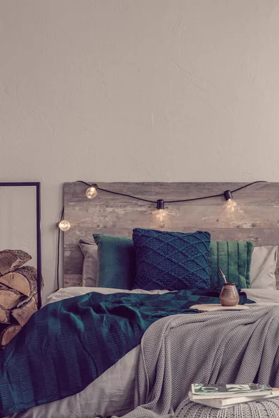 Pionowy widok rustykalnego projektowania sypialni i miejsca na kopię na pustej szarej ścianie — Zdjęcie stockowe