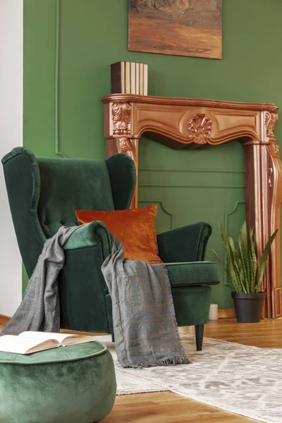 Emerald grön vinge ryggstol med orange kudde i lyxigt vardagsrum interiör — Stockfoto