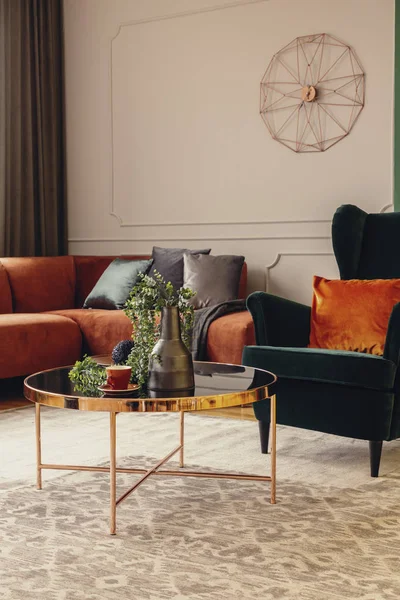 Изумрудно-зеленое заднее кресло с оранжевой подушкой в роскошном интерьере гостиной — стоковое фото