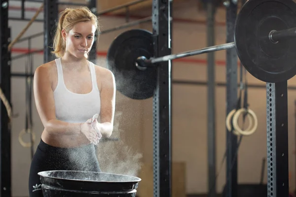 Güzel sarışın kız spor salonunda ağırlık kaldırmaya hazırlanıyor. — Stok fotoğraf