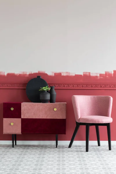 トレンディーなピンクとバーガンディ商品の横にスタイリッシュな小さなパステルピンクの椅子 — ストック写真