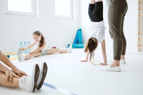 Діти вправляються під час фізичного виховання в шкільному спортзалі — стокове фото