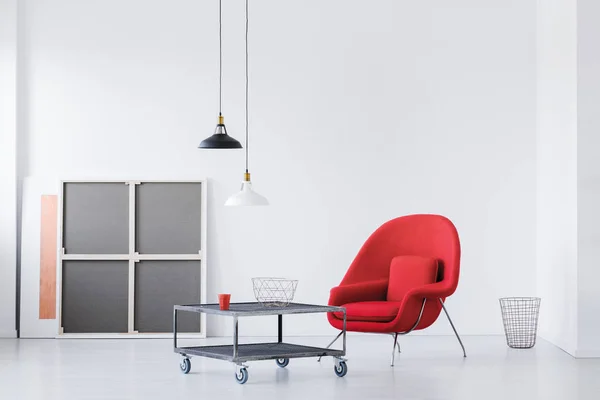 Red armchair and metal coffee table in a modern daily room interior. Real photo