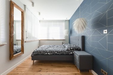 Ahşap çerçevedeki ayna şık yatak odasının iç kısmında kral yatağı ve süslü avizesi var.