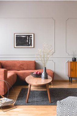 Zencefil kanepe ile şık gri oturma odası iç köşesinde siyah vazolar ile Retro ahşap dolap