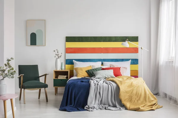 Ретро крісло в сучасному інтер'єрі спальні з райдужним кольором ліжка — стокове фото
