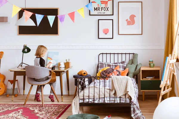 Petite fille mignonne assise au bureau dans sa chambre vintage élégante avec espace de travail — Photo