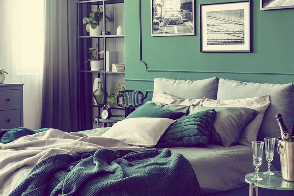 Przytulne łóżko z poduszkami i kocami w szmaragdowych i szarych kolorach — Zdjęcie stockowe