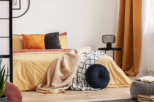 Стильный дизайн спальни с оранжевым и желтым цветами в современных апартаментах — стоковое фото