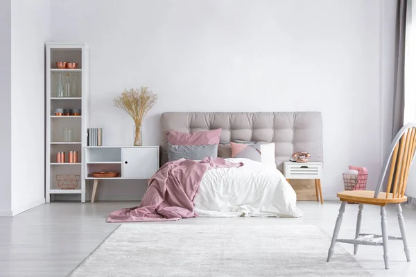 ヘッドボードと白の木製家具と快適なベッドと明るい寝室のインテリアの床の白い敷物 — ストック写真