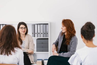 Terapi seansında birbirlerine destek olan bir grup kadın.