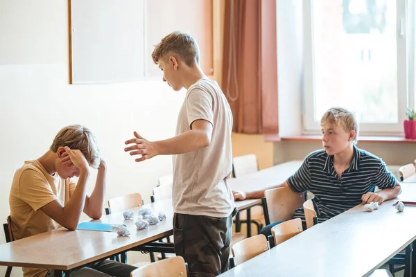 Zlí Kluci Šikanují Spolužáka Sedícího Školního Stolu — Stock fotografie