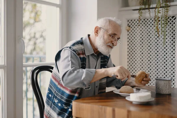 シニア悲しい男食べる朝食一人で彼の家 — ストック写真