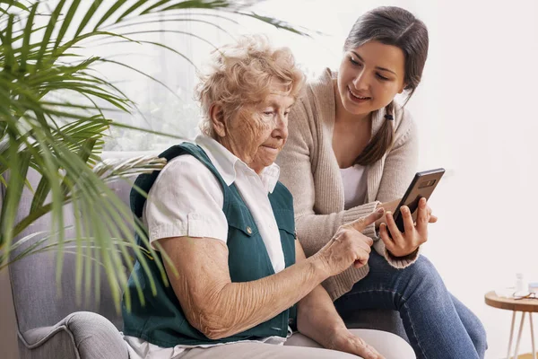 Šťastná Vnučka Ukazující Zprávu Své Babičce Mobilním Telefonu — Stock fotografie