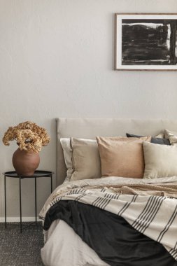 İskandinav yatak odası iç kral yatak yanında metal komandite üzerinde çanak çömlek vazo kahverengi çiçekler