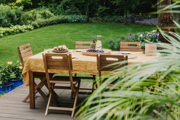 Esstisch Mit Orangefarbener Tischdecke Auf Holzterrasse Grünen Garten — Stockfoto