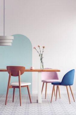 Uzun ahşap yemek masasında küçük vazolarda yeşil bitkiler.