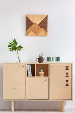 Uzun ahşap yemek masasında küçük vazolarda yeşil bitkiler.