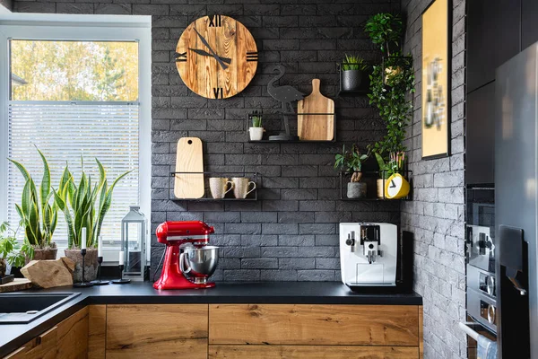 赤キッチンロボットと流行のキッチンで黒レンガの壁に木製の時計 — ストック写真