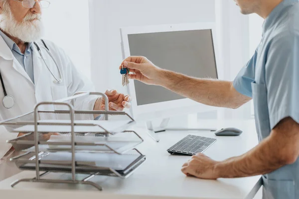 Primer Plano Enfermera Dando Las Llaves Del Consultorio Médico Mayor — Foto de Stock