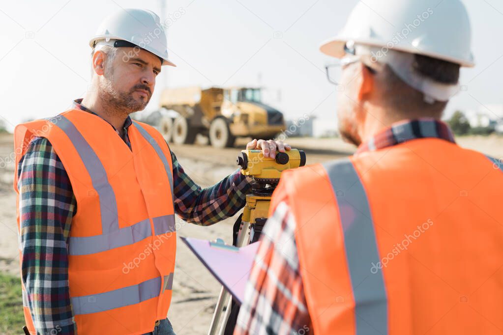 Construction workers setting equipment in the middle of the road structure