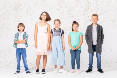 Bir grup mutlu çocuk bir odada yan yana duruyor.