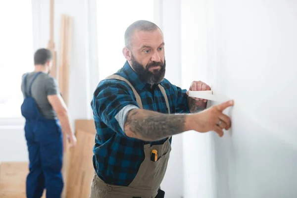 Professionell Byggare Sätter Tejp Tom Vägg Innan Målar Den — Stockfoto