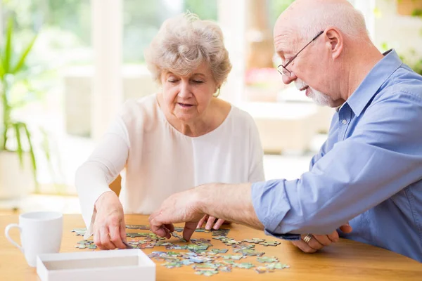 Süße Oma Und Opa Setzen Puzzleteile Hause Zusammen — Stockfoto
