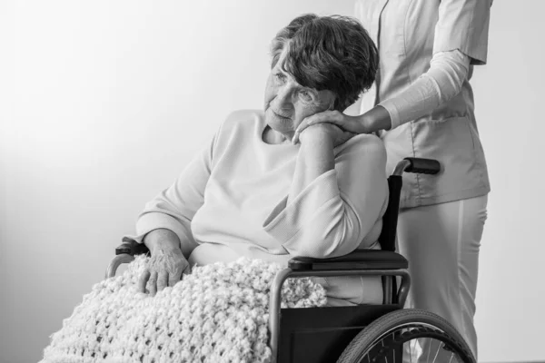 Smutný Senior Invalidním Vozíku Dotýká Ruku Zdravotní Sestry Tváří — Stock fotografie