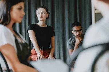 Genç endişeli kız arkadaşlarıyla grup psikoterapisinde oturuyor.