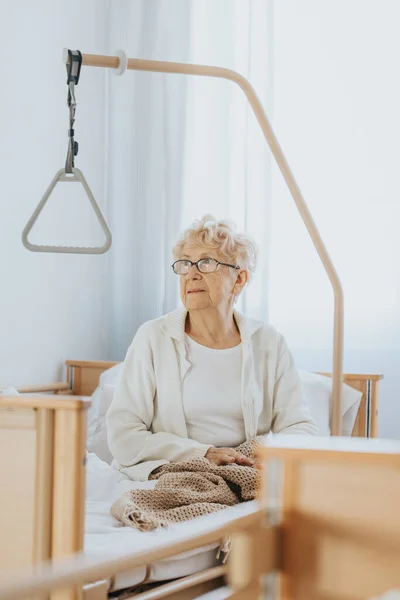 Grootmoeder Met Bril Zit Het Bed Het Verpleeghuis — Stockfoto