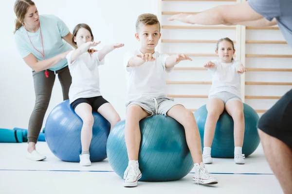 Grupo Bonito Crianças Exercitando Com Bolas Durante Aula Esporte Escola — Fotografia de Stock