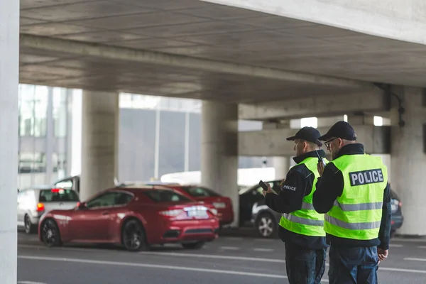 Parkovišti Stojí Policisté Černých Uniformách Žlutých Vestách — Stock fotografie