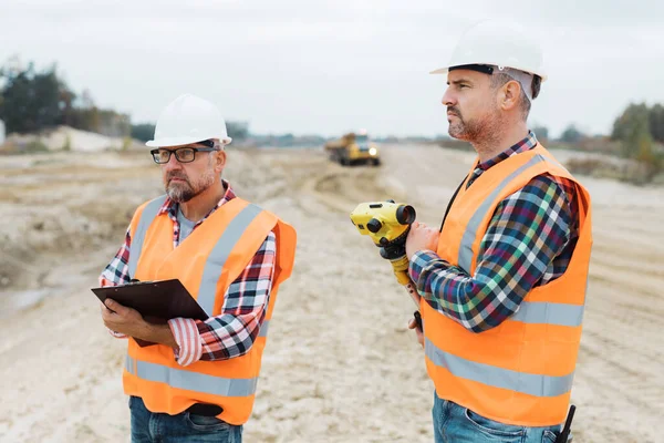 Due Operai Delle Costruzioni Stradali Che Utilizzano Dispositivo Misurazione Sul — Foto Stock