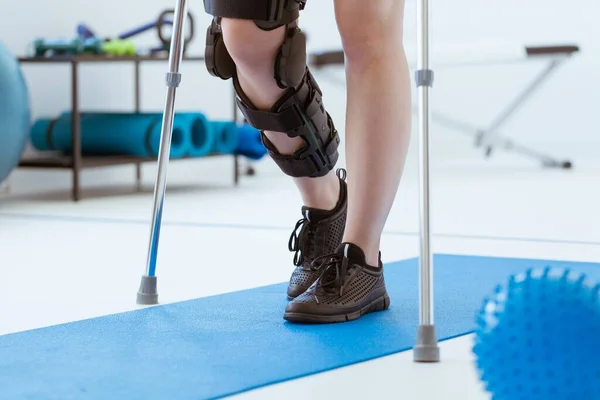 Injured Patient Leg Brace Exercising Blue Mat Physiotherapy Office — Stock Photo, Image