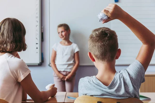 Ohyfsad Ung Pojke Kastar Pappersboll Flickan Lektionerna — Stockfoto