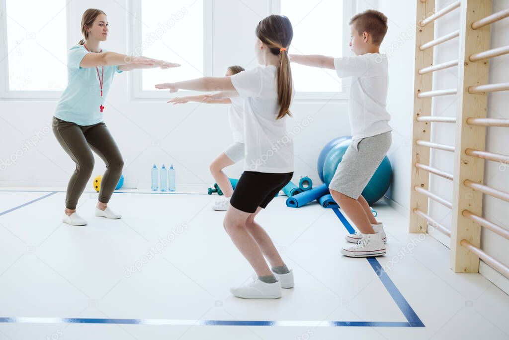 Kids exercising during physical education at school gym