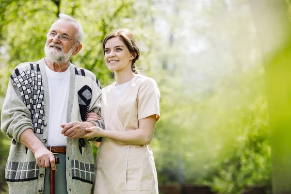 Homme Âgé Avec Bénévole Serviable Dans Jardin Maison Soins Professionnels — Photo