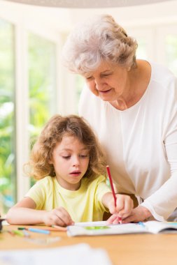 Büyükannesi torunuyla bir resim çiziyor.