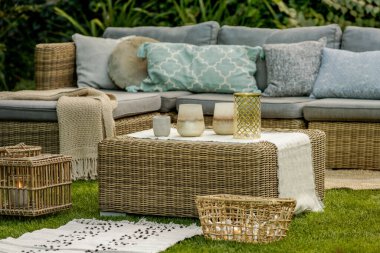 Fenerler, mumlar ve vazolar bahçe kanepesinin önündeki sehpada.