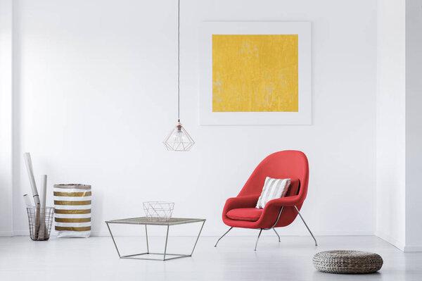 Современный интерьер гостиной с красным креслом и желтой росписью
