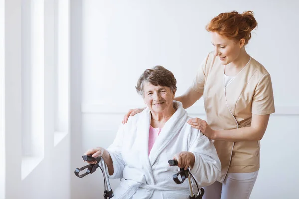 Jonge Mooie Verpleegster Helpen Gehandicapte Patiënt Verhuizen Met Een Walker — Stockfoto