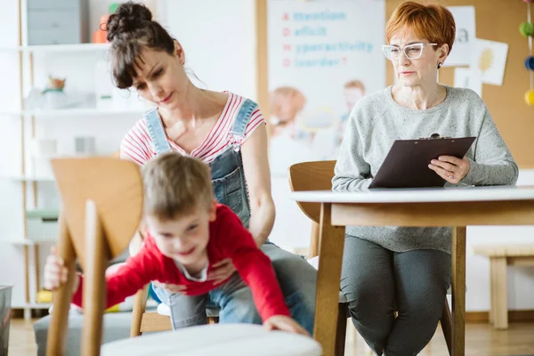 Jeune Maman Tenant Garçon Avec Adhd Pendant Session Avec Psychothérapeute Photo De Stock