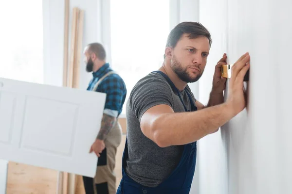 Präzise Junge Bauarbeiter Überprüfen Das Niveau Der Wand Stockbild